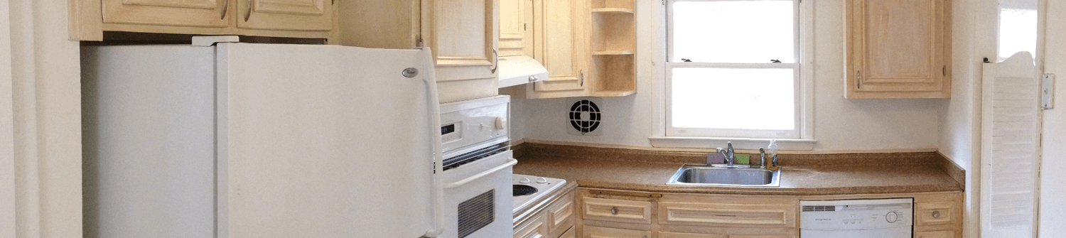 a remodeled kitchen with solid wood cabinets and white appliances