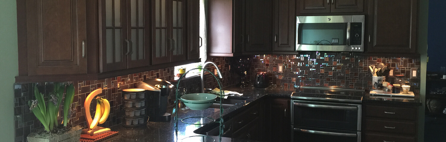 a remodeled kitchen with tile backsplash and recessed lighting below the cabinets