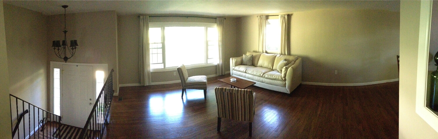 the living room and main entry stairway in a completely refurbished house